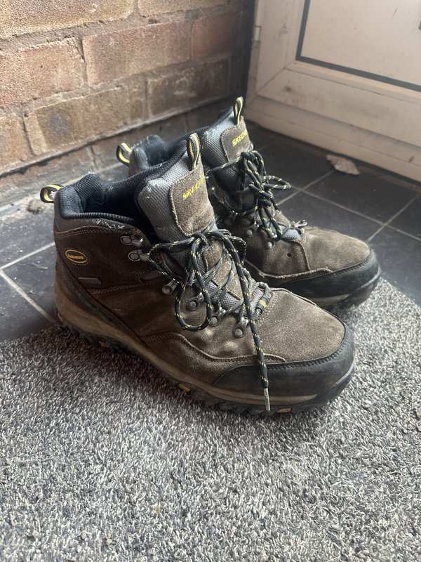 Original phone photo of hiking boots on a doormat